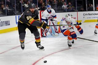 Vegas Golden Knights right wing Alex Tuch (89) and New York Islanders defenseman Nick Leddy (2) chase the puck during an NHL hockey game at T-Mobile Arena, Thursday, Dec. 20, 2018.