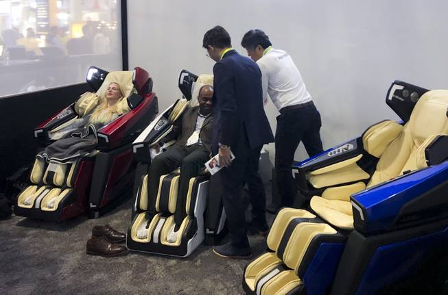 Attendees try out some luxury Lamborghini massage chairs.