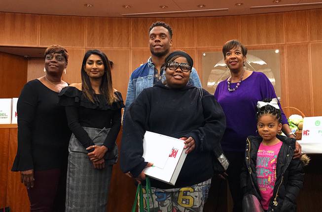 Barbara Marshall, from left, Shenali Rajaratnam, the founder of ShopNowToFund, Brandon Marshall and North Las Vegas Mayor Pro Tem Pamela Goynes-Brown stand with one of the families who received a FEEL box at North Las Vegas City Hall on Thursday, Jan. 10, 2019.