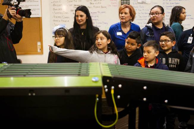 CC Ronnow Elementary School Principal Shelly Crawford, back left, and students watch a book sorting machine during a tour by Carlos Santana and his Milagro Foundation staff at the Spread the Word Nevada offices and warehouse in Henderson, NV, Thursday, Jan. 17, 2019. The Milagro Foundation made a donation to Spread the Word, which will provide about 15,000 books to 57 schools across Southern Nevada.