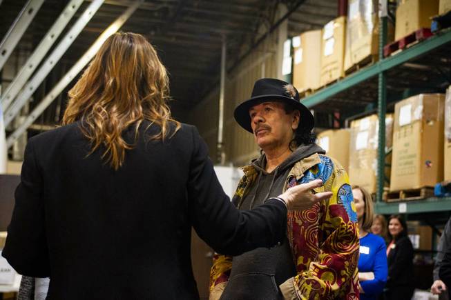 Carlos Santana, right, listens to Spread the Word Executive Director/Co-Founder Lisa Habighorst, left, during a tour by Carlos Santana, his wife and his Milagro Foundation staff at the Spread the Word Nevada offices and warehouse in Henderson, NV, Thursday, Jan. 17, 2019. The Milagro Foundation made a donation to Spread the Word, which will provide about 15,000 books to 57 schools across Southern Nevada.