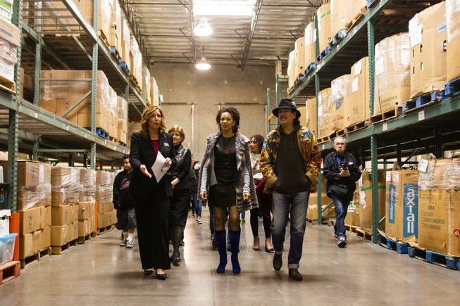 Spread the Word Executive Director/Co-Founder Lisa Habighorst, left, gives a tour to Carlos Santana, front left, and his wife Cindy Blackman, front center, at the Spread the Word Nevada offices and warehouse in Henderson, NV, Thursday, Jan. 17, 2019. Carlos Santana's Milagro Foundation made a donation to Spread the Word, which will provide about 15,000 books to 57 schools across Southern Nevada.