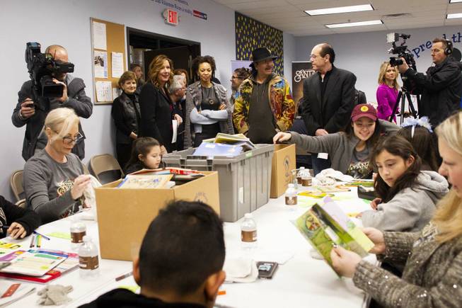 Spread the Word Executive Director/Co-founder Lisa Habighorst, center left, gives a tour to Carlos Santana, center right, and his wife Cindy Blackman, center left, at the Spread the Word Nevada offices and warehouse in Henderson, NV, Thursday, Jan. 17, 2019. Carlos Santana's Milagro Foundation made a donation to Spread the Word, which will provide about 15,000 books to 57 schools across Southern Nevada.