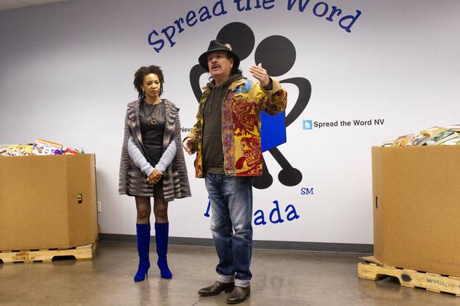 Carlos Santana speaks as his wife Cindy Blackman, left, looks on during a tour at the Spread the Word Nevada offices and warehouse in Henderson, NV, Thursday, Jan. 17, 2019. Santana's Milagro Foundation made a donation to Spread the Word, which will provide about 15,000 books to 57 schools across Southern Nevada.