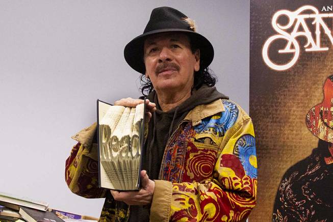Carlos Santana poses for a photo with a gift from Spread the Word Nevada Foundation during a tour at the Spread the Word offices and warehouse in Henderson, NV, Thursday, Jan. 17, 2019. Santana's Milagro Foundation made a donation to Spread the Word, which will provide about 15,000 books to 57 schools across Southern Nevada.