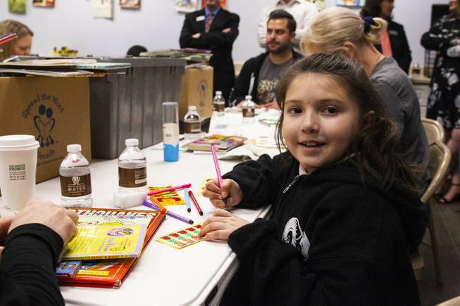 CC Ronnow Elementary School student Flor Aguirre colors during a tour by Carlos Santana and his Milagro Foundation staff at the Spread the Word Nevada offices and warehouse in Henderson, NV, Thursday, Jan. 17, 2019. The Milagro Foundation made a donation to Spread the Word, which will provide about 15,000 books to 57 schools across Southern Nevada including lower socioeconomic schools like CC Ronnow Elementary School.