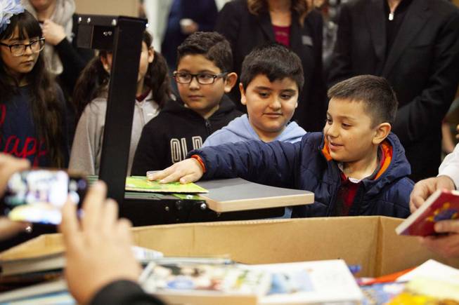 CC Ronnow Elementary School students try out the book sorting machine during a tour by Carlos Santana and his Milagro Foundation staff at the Spread the Word Nevada offices and warehouse in Henderson, NV, Thursday, Jan. 17, 2019.  The Milagro Foundation made a donation to Spread the Word, which will provide about 15,000 books to 57 schools across Southern Nevada including lower socioeconomic schools like CC Ronnow Elementary School.