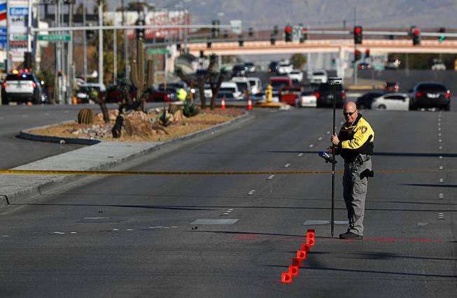 A member of Metro Police Department's fatal detail takes measurements ...