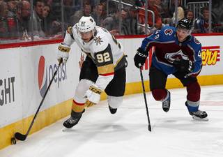 Vegas Golden Knights left wing Tomas Nosek, left, picks up the puck as Colorado Avalanche defenseman Samuel Girard pursues in the second period of an NHL hockey game Monday, Feb. 18, 2019, in Denver.