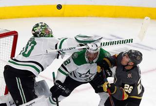 The puck flies over Dallas Stars goaltender Ben Bishop (30) during the first period at T-Mobile Arena Tuesday, Feb. 26, 2019. Dallas Stars defenseman Jamie Oleksiak (2) and Vegas Golden Knights center Paul Stastny (26) are at right.