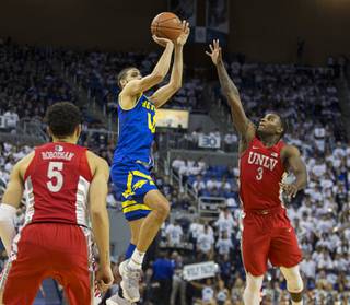 Nevada forward Caleb Martin (10) shoots over UNLV guard Amauri Hardy (3) in the second half of an NCAA college basketball game in Reno, Nev., Wednesday, Feb. 27, 2019. (AP Photo/Tom R. Smedes)