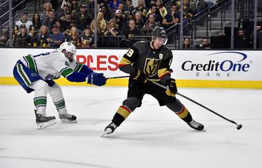 Vegas Golden Knights right wing Reilly Smith (19) shoots against Vancouver Canucks center Jay Beagle (83) during the second period of an NHL hockey game Sunday, March 3, 2019, in Las Vegas.