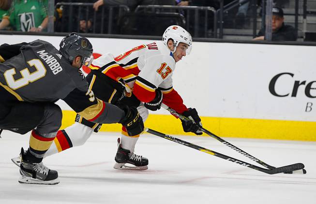 Calgary Flames left wing Johnny Gaudreau (13) skates around Vegas Golden Knights defenseman Brayden McNabb (3) during the first period of an NHL hockey game Wednesday, March 6, 2019, in Las Vegas.