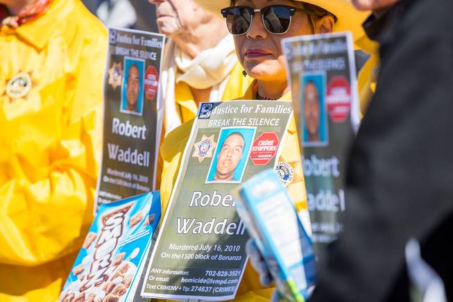 Metro Volunteers hold signs asking the public for any information regarding the slaying of Robert Waddell back in July of 2010, Thursday March 14, 2019.