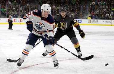 Edmonton Oilers center Colby Cave (12) takes a shot as Vegas Golden Knights defenseman Shea Theodore defends during the third period of an NHL hockey game Sunday, March 17, 2019, in Las Vegas. The Golden Knights won, 6-3.