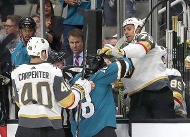 San Jose Sharks center Micheal Haley, center, goes after Vegas Golden Knights right wing Ryan Reaves (75) on the bench as center Ryan Carpenter (40) holds his jersey during the first period of an NHL hockey game in San Jose, Calif., Monday, March 18, 2019.