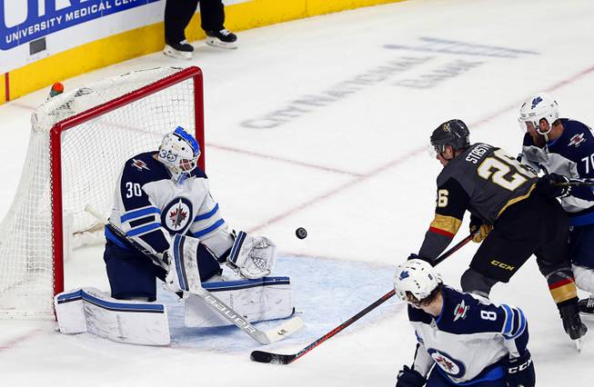 Winnipeg Jets goaltender Laurent Brossoit (30) blocks a shot by Vegas Golden Knights center Paul Stastny (26) in the first period at T-Mobile Arena Thursday, March 21, 2019.