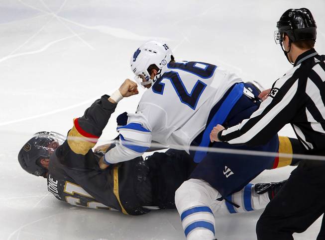 Vegas Golden Knights right wing Mark Stone, bottom, punches at Winnipeg Jets right wing Blake Wheeler (26) during a fight in the first period at T-Mobile Arena Thursday, March 21, 2019.