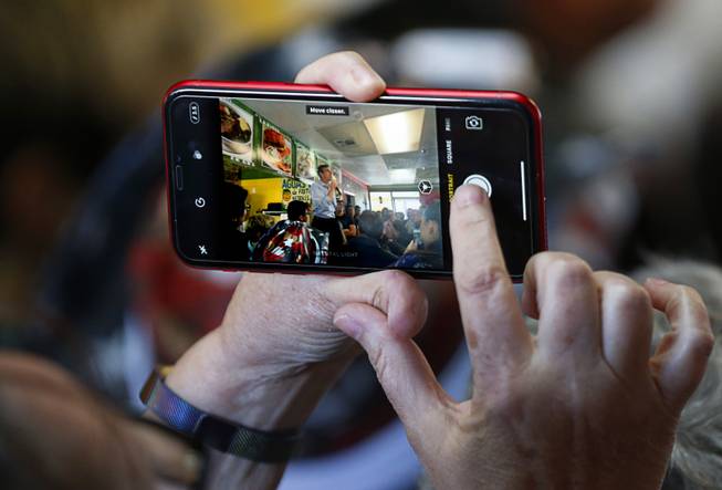 A woman takes a photo of Democratic presidential candidate Beto O'Rourke of Texas as he makes a campaign stop at Arandas Taqueria on North Nellis Boulevard Sunday, March 24, 2019.