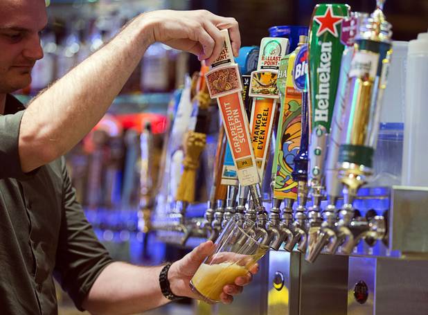 Blaise Pfabe, assistant beverage manager, pours a glass of Grapefruit Sculpin IPA in the 32 Degrees Draft Bar at the M Resort in Henderson Thursday, March 28, 2019. The bar features 96 beers on tap.