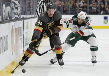 Vegas Golden Knights right wing Mark Stone (61) skates around Minnesota Wild center Luke Kunin (19) during the second period of an NHL hockey game Friday, March 29, 2019, in Las Vegas. (AP Photo/John Locher)