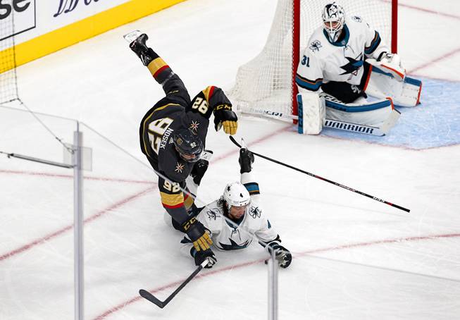 Vegas Golden Knights left wing Tomas Nosek (92) falls over  San Jose Sharks defenseman Brenden Dillon (4) after getting his stick stuck in Dillon's skate in the first period during Game 6 of an NHL hockey first-round playoff series at T-Mobile Arena Sunday, April 21, 2019.