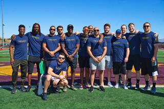 Caric Sports Management clients and staff pose for a photo during a company retreat, which included a free youth football camp at Faith Lutheran High School.  