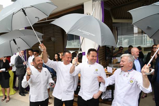 Chefs joke with umbrellas while a light rain falls as Vegas Uncork'd kicks off its 13th year with a ceremonial 