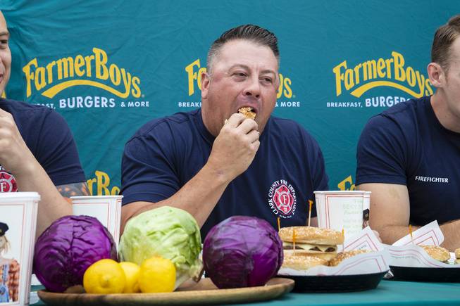 Las Vegas County Fire firefighter Erik Oliver eats a Barn Burner burger during a burger eating contest at Farmer Boys Thursday, May 16, 2019. In celebration of National Burger Month teams of firefighters from Las Vegas County Fire and Las Vegas Fire & Rescue gathered for a head-to-head burger eating contest benefitting The Southern Nevada Burn Foundation. Farmer Boys donated $100 for each burger eaten by the firefighters during the 20 minute competition to the foundation, which supports fire victims and their families. Together the firefighters ate 47 burgers winning $4,700 for the foundation.