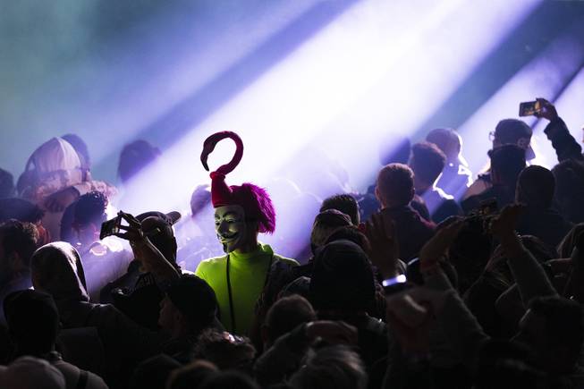 A festival-goer wears a Guy Fawkes mask and a flamingo  while Illenium performs during night three of the Electric Daisy Carnival at the Las Vegas Motor Speedway Monday, May 20, 2019.