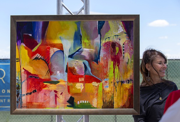 Las Vegas artist Niki Sands stands by her painting, an untitled oil on linen, after an unveiling during a groundbreaking ceremony for Auric, a luxury, mid-rise apartment complex by Southern Land Company (SLC), at Symphony Park in downtown Las Vegas, May 21, 2019. The complex will be built on six acres of vacant land north of the Smith Center for the Performing Arts.