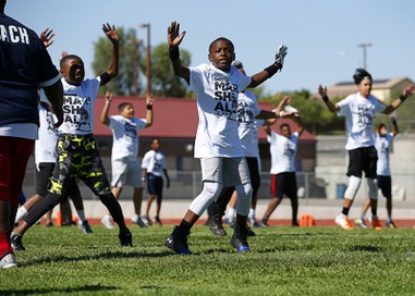 Kimon Tiffith, 10, does jumping jacks during a football camp at Canyon Springs High School Saturday, June 8, 2019. 
