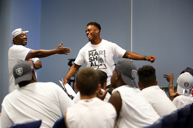 Ennis William, left, and Brandon Marshall react to a boy's ...