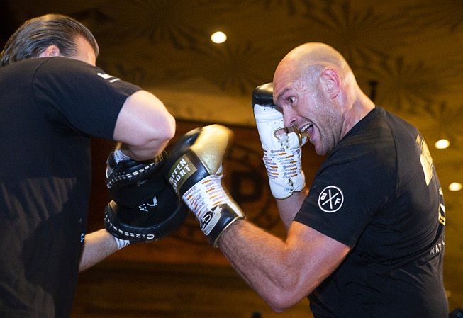 Heavyweight boxer Tyson Fury, right, of England works on his ...