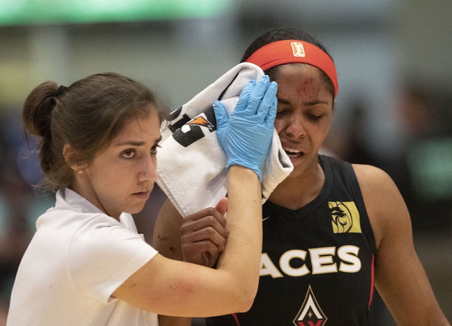 Las Vegas Aces' Sydney Colson, right, is led off the ...