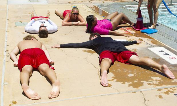 Lifeguards warm up on the cement ground during the World's Largest Swim Lesson event at the Boulder City Swimming Pool Thursday, June 20, 2019.  The World's Largest Swim Lesson is a world wide event to promote awareness and safety when swimming.