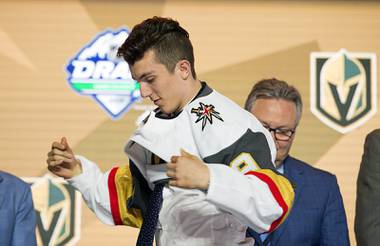 Peyton Krebs puts on a Vegas Golden Knights jersey during the first round of the NHL hockey draft Friday, June 21, 2019, in Vancouver, British Columbia. 