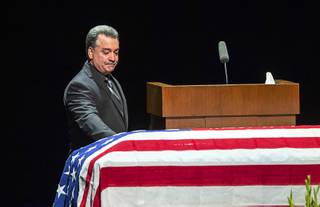 Long-time friend Dennis Flynn touches the casket during a memorial service for former Metro Police Capt. Larry Burns Jr. at the Smith Center Thursday, July 18, 2019. Flynn is a former Metro Police lieutenant.