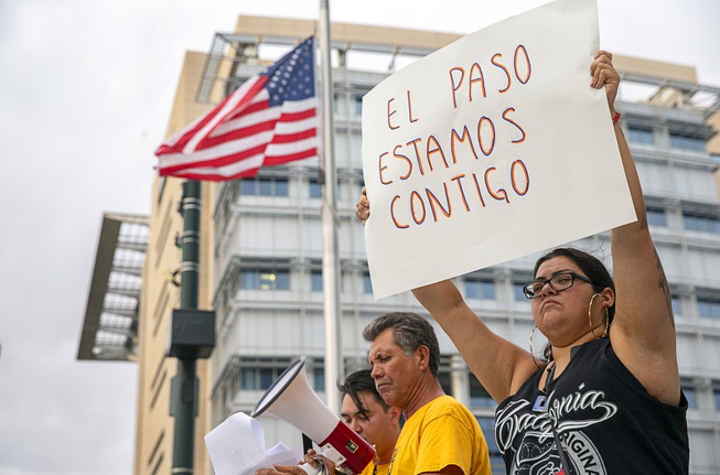 Yesenia Moya Garay holds up a sign in Spanish that ...