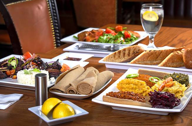 An Ethiopian meal is displayed at NU Ethiopian Kitchen, 4230 S. Decatur Blvd., Tuesday, Aug. 6, 2019. Shown are Goden Tibs, left, Fish (tilapia) Salad, top, and a Vegetarian Platter.