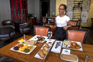 Co-owner Mini Yohannes poses behind an Ethiopian meal at NU Ethiopian Kitchen, 4230 S. Decatur Blvd., Tuesday, Aug. 6, 2019.