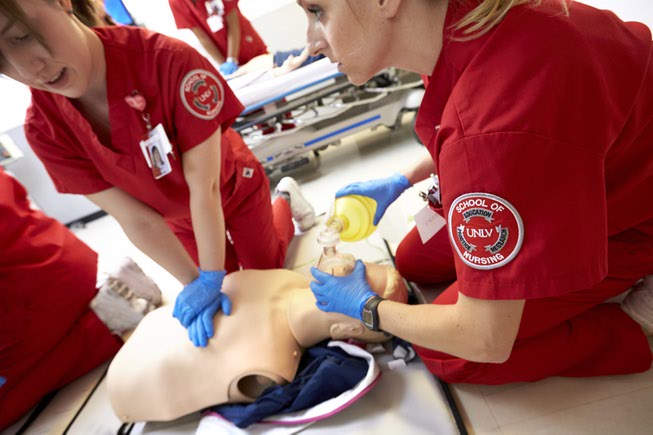 UNLV Nursing students perform CPR on a manikin in the ...