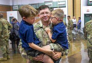 First Lt. David Henry holds his sons Owein, 7, and Carrick, 5, following a mobilization ceremony for the the Nevada Army Guard 3665th Explosive Ordnance Disposal Company at Las Vegas Readiness Center Tuesday, Aug. 20, 2019. The ceremony marks the start of the company's 10-month mission in Afghanistan.