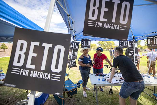Twila Burns, left, and Lydia Saulsberry look over information at a tent for Democratic presidential candidate Beto O'Rourke during Congressman Steven Horsford's Labor Day Cookout at Craig Ranch Regional Park in North Las Vegas, Sept. 2, 2019.