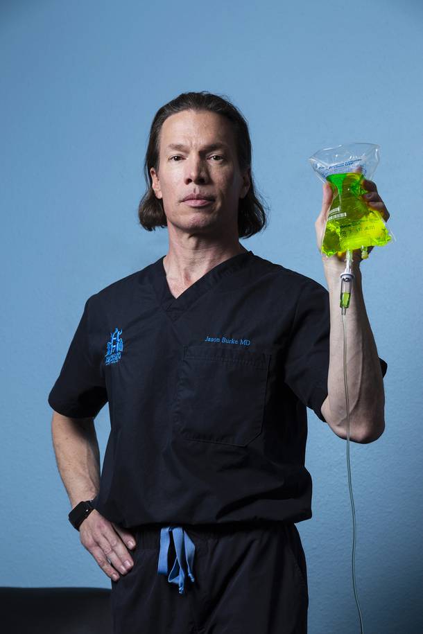Dr. Jason Burke, M.D., poses for a portrait with a vitamin IV bag at the Hangover Heaven IV Hydration clinic Monday, Sept. 16, 2019.