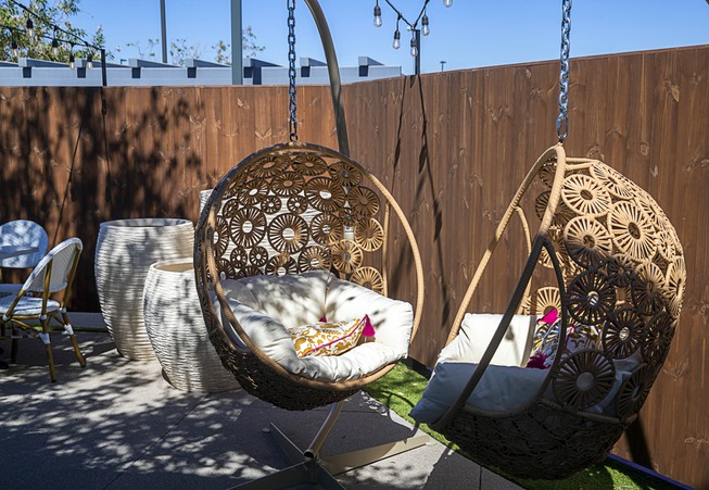 Hanging chairs are shown in an outdoor courtyard at Firefly ...