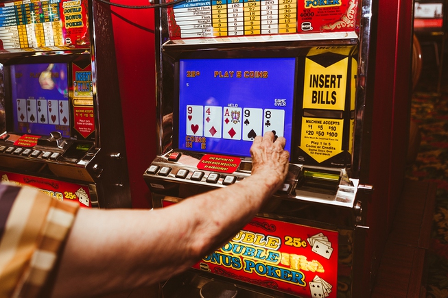 A local gambler plays simultaneously on two coin slot machines ...