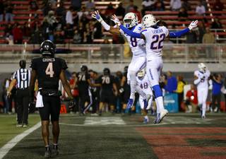 Boise State Broncos cornerback Markel Reed (8) and teammate Tyric LeBeauf (22)  celebrate after shutting down a UNLV Rebels drive in the fourth quarter of a game at Sam Boyd Stadium Saturday, Oct. 5, 2019. UNLV Rebels wide receiver Randal Grimes (4) looks on a t left.