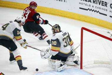 Arizona Coyotes right wing Conor Garland (83) sends the puck past Golden Knights defenseman Nicolas Hague (14) and Golden Knights goaltender Malcolm Subban for a goal during the first period of an NHL hockey game Thursday, Oct. 10, 2019, in Glendale, Ariz. 