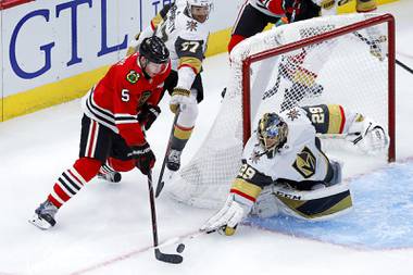 Golden Knights goaltender Marc-Andre Fleury poke-checks the puck away from Chicago Blackhawks defenseman Connor Murphy during the first period of an NHL hockey game Tuesday, Oct. 22, 2019, in Chicago. 